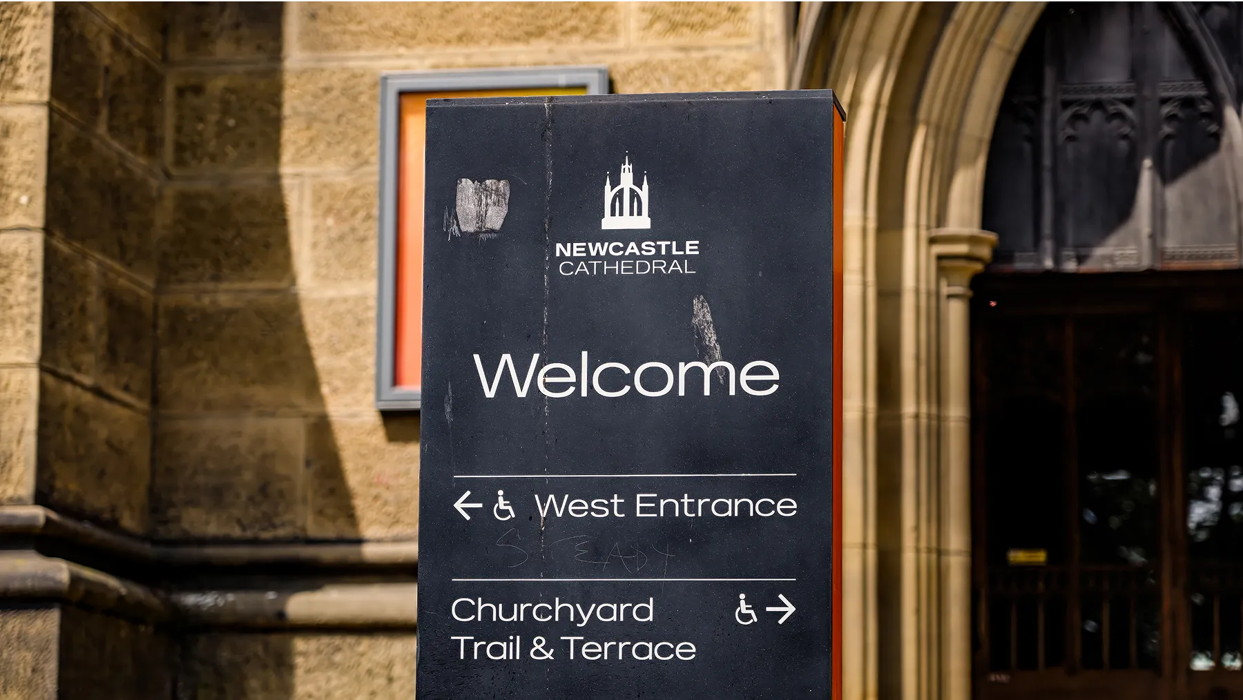 Directional sign in front of cathedral directing event goers to their proper destination. 